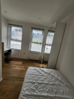 A bright and tidy single bedroom featuring larg...