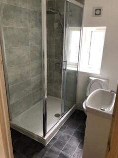 A clean bathroom featuring a shower, with good ...