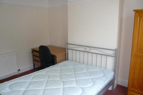 A spacious and tidy double bedroom featuring a ...