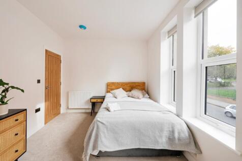 A bright and clean double bedroom featuring a c...