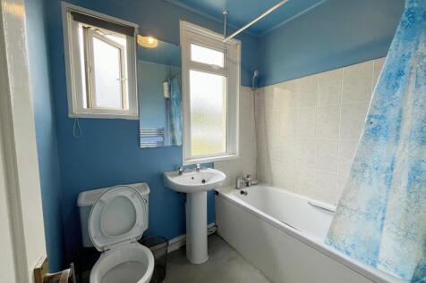 A bright and tidy bathroom featuring a bath and...