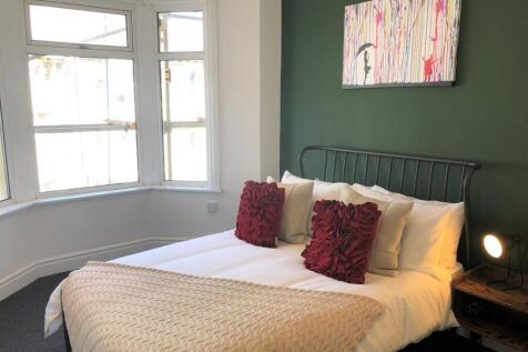 A spacious and inviting double bedroom with amp...