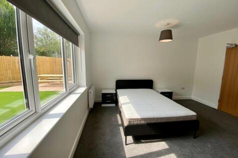 A spacious and bright double bedroom featuring ...
