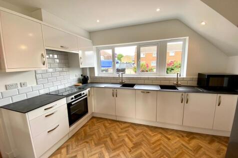 A bright and modern kitchen featuring sleek cab...