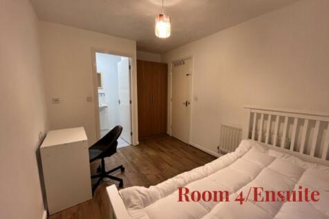 A bright and inviting double bedroom with an en...