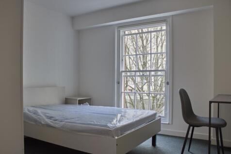 A bright and clean double bedroom with a cozy a...