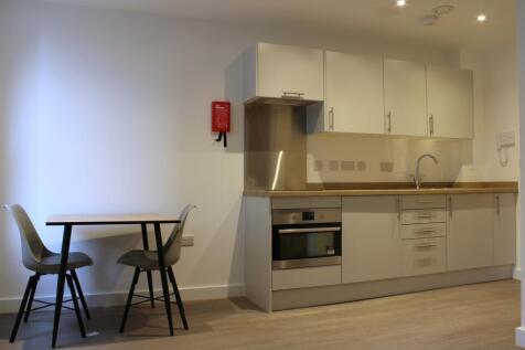 A modern and tidy kitchenette with ample storag...