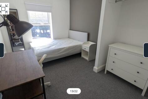 A bright and spacious double bedroom with styli...