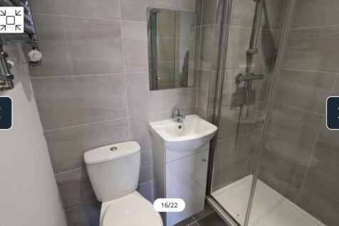 A modern and clean bathroom featuring a shower,...