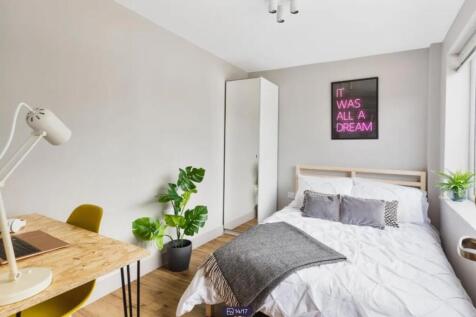 A bright and modern double bedroom featuring st...
