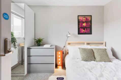 A bright and modern double bedroom featuring st...