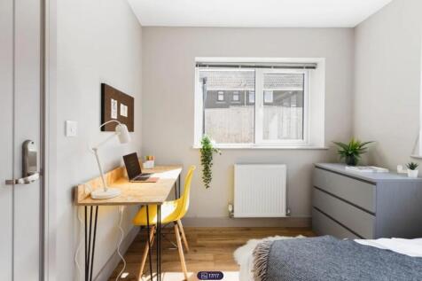 A bright and clean double bedroom featuring a w...