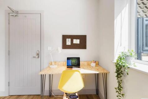 A bright and inviting communal workspace featur...