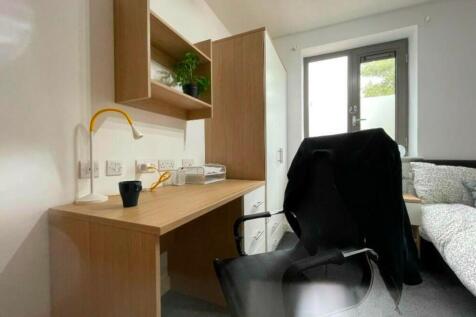 A well-furnished double bedroom with a cozy des...