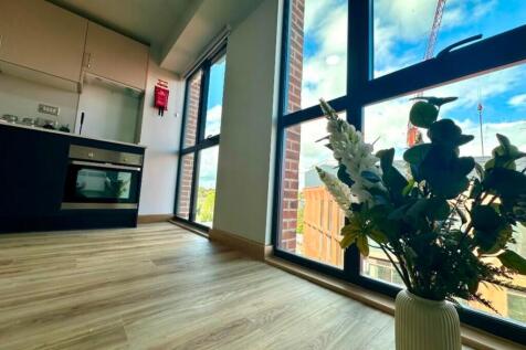 A bright and modern kitchenette with large wind...