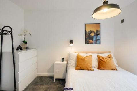 A bright and inviting double bedroom with styli...