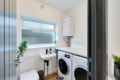 A bright and modern bathroom featuring a washin...