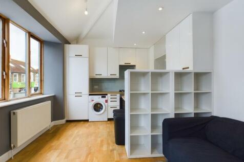 A bright and modern kitchenette with ample stor...