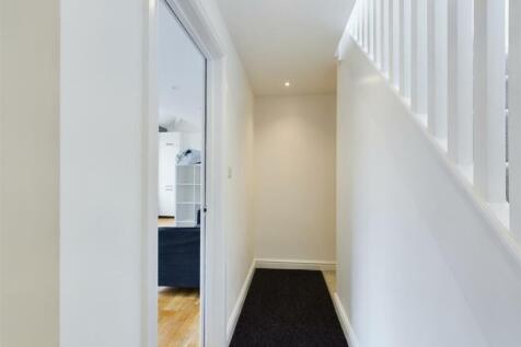 A bright and tidy hallway leading to inviting l...