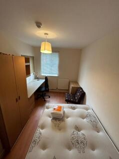 A cozy double bedroom featuring a desk and comf...