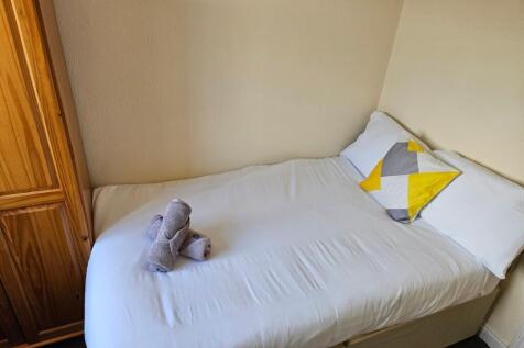 A cozy and tidy single bedroom featuring a comf...