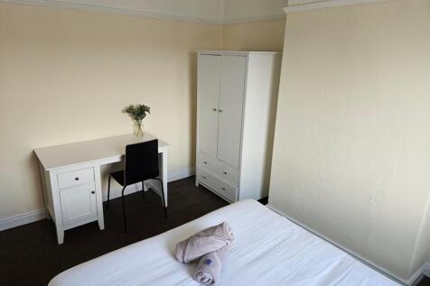 A bright and tidy double bedroom featuring a de...