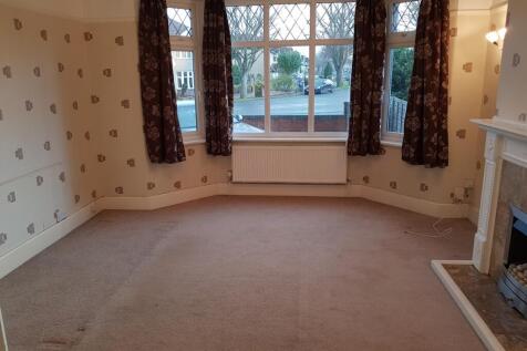 A spacious and bright living room with large wi...
