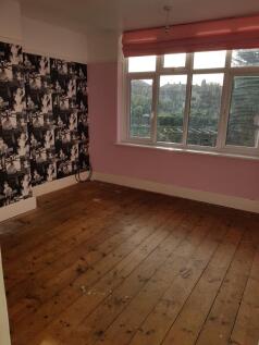 A spacious double bedroom featuring large windo...