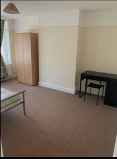 A spacious and tidy double bedroom featuring a ...