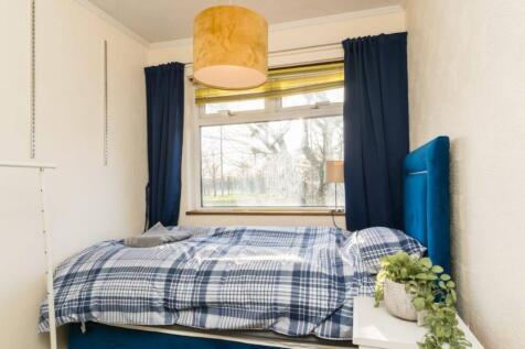 A cozy and well-lit double bedroom featuring la...
