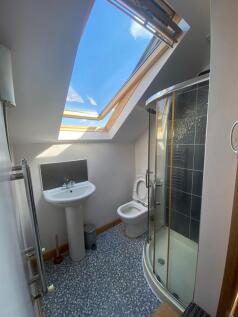 A bright and modern bathroom featuring a skylig...