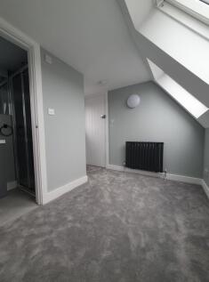 This inviting double bedroom features soft grey...