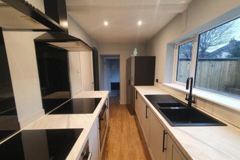 A modern kitchen featuring sleek cabinetry, amp...