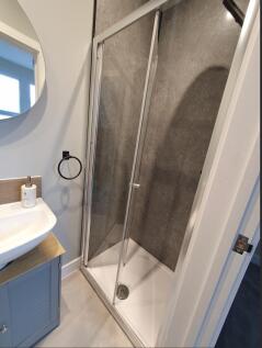 A modern bathroom featuring a sleek shower encl...