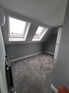 A charming double bedroom featuring sloped ceil...