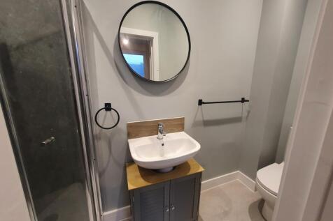 A modern bathroom featuring a stylish shower, c...