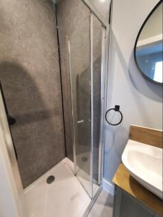 A modern bathroom featuring a sleek shower unit...