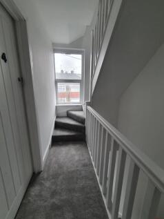 Bright and airy hallway featuring a stylish sta...