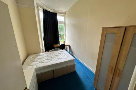 A cozy double bedroom featuring a large window ...