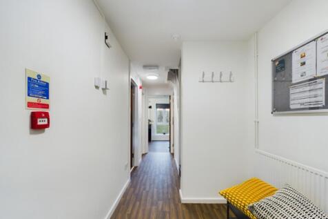 A bright and tidy hallway leading to various ro...