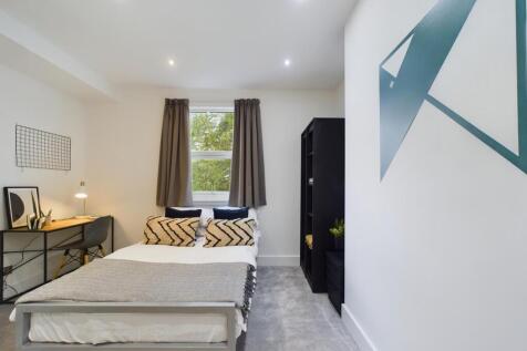 A spacious and well-lit double bedroom with mod...