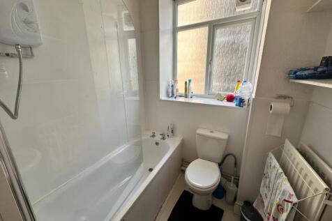 A bright and tidy bathroom featuring a bathtub ...