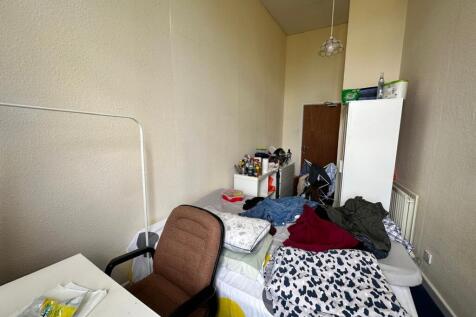 A spacious double bedroom with natural light an...