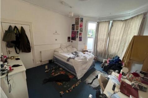 A spacious double bedroom with large windows th...