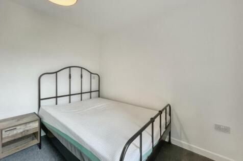 A spacious and tidy double bedroom featuring a ...