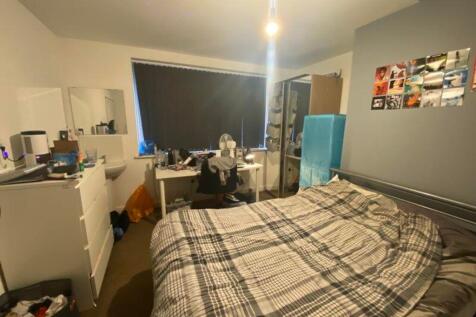 A cozy double bedroom with ample space for stud...