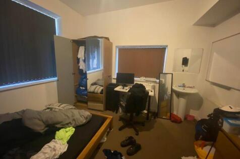A cozy double bedroom with ample space for stud...