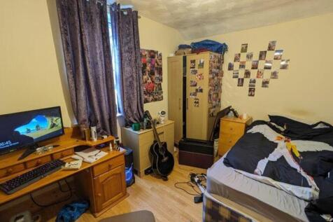 A cozy double bedroom with a desk and good natu...