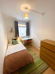 A bright and tidy single bedroom featuring a co...