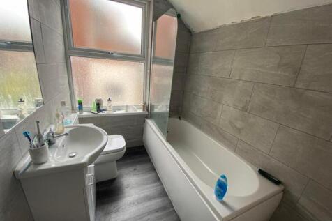 A bright and modern bathroom featuring a bathtu...